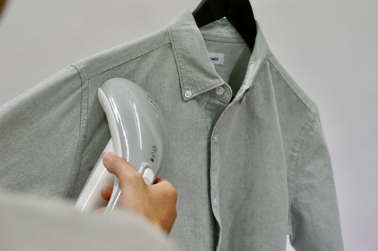 handheld steamer being used on a shirt