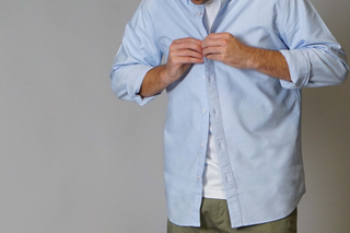 Model buttoning up an Oxford Shirt