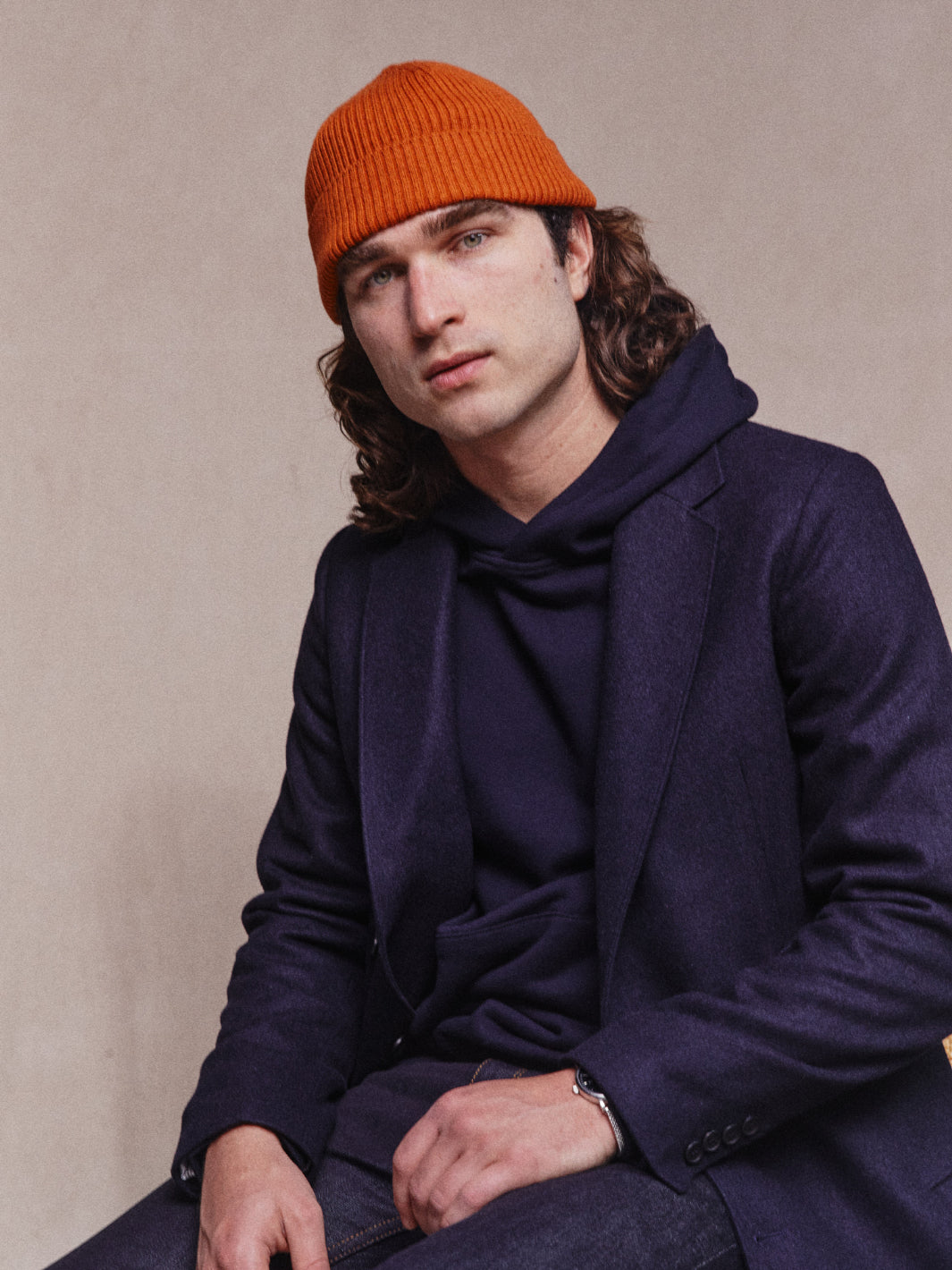 Close up model shot of Asuwere Woollen Topcoat in Navy with navy hoodie and orange beanie