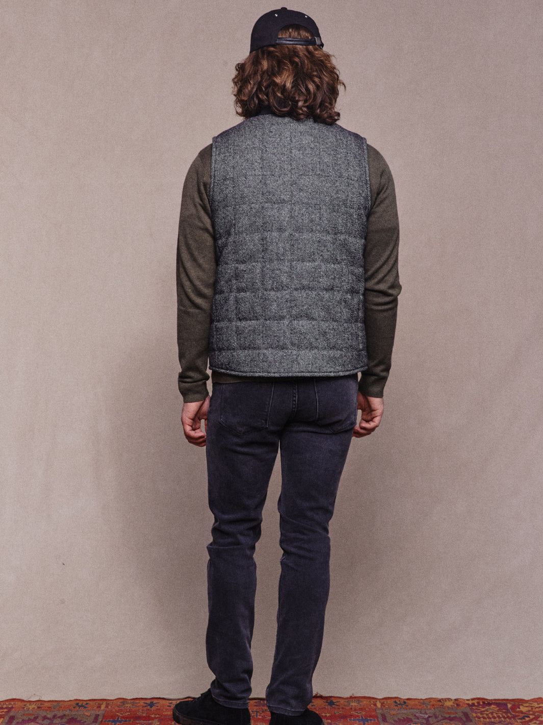 Full back length shot of model wearing Quilted Vest in Charcoal