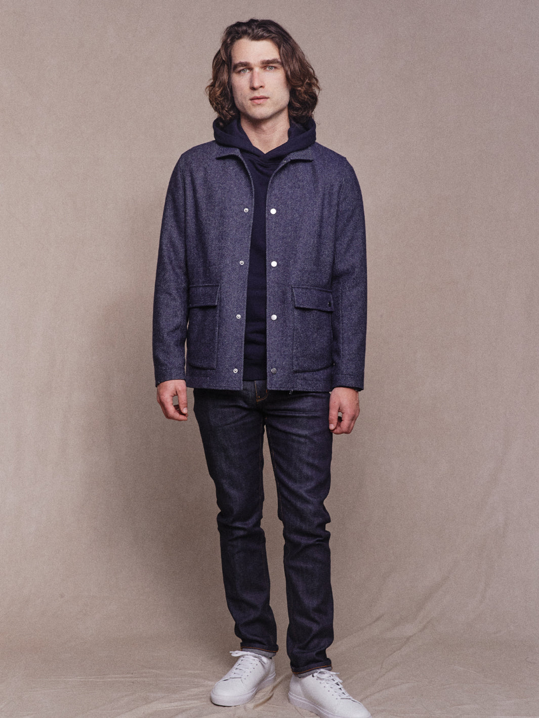Full body image of model wearing Heavy Woollen Overshirt in Navy with Navy Hoodie, Navy Jeans and White Sneakers