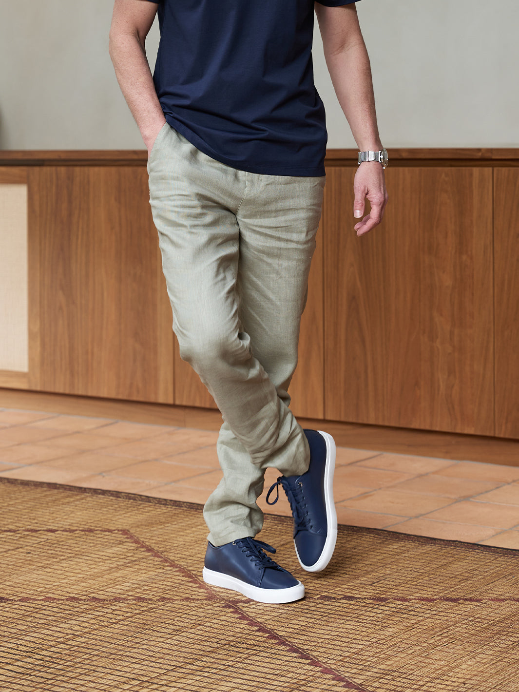 Model wearing Leather Low Sneaker in Navy with light green linen chinos