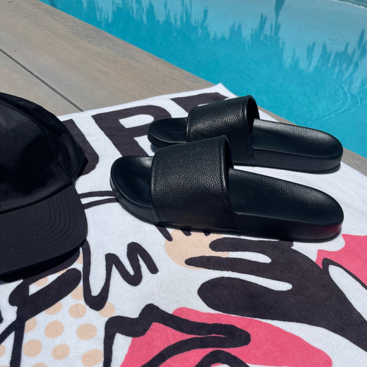 Black Leather Low Slides on pink and white towel by pool
