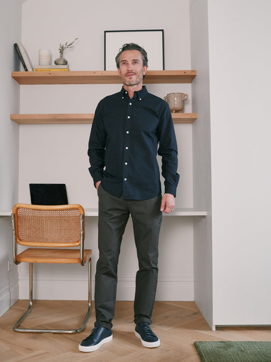 Model wearing navy oxford shirt with khaki chino and navy leather sneakers